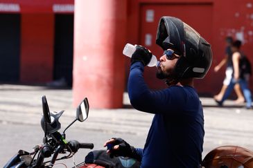 Rio de Janeiro (RJ), 17/02/2024 -Transeuntes se protegem do forte calor nas ruas do centro da cidade. Cidade do Rio de Janeiro atinge nível 4 de calor. Marco é caracterizado por temperaturas que podem chegar a 44ºC  Foto: Tânia Rêgo/Agência Brasil