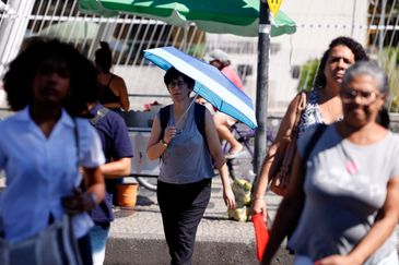 Rio de Janeiro (RJ), 17/02/2024 -Transeuntes se protegem do forte calor nas ruas do centro da cidade. Cidade do Rio de Janeiro atinge nível 4 de calor. Marco é caracterizado por temperaturas que podem chegar a 44ºC  Foto: Tânia Rêgo/Agência Brasil