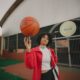 woman in red and white nike jersey holding basketball