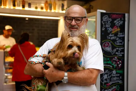 Rio de Janeiro(RJ), 24/09/25 - O aposentado, Luís Sérgio Touche e seu cachorrinho, Zé, passeiam no novo merdado. O Mercado São José, em Laranjeiras. que estava fechado há 7 anos volta a funcionar como espaço para compras de hortifruti, restaurantes e música. Foto: Tânia Rêgo/Agência Brasil