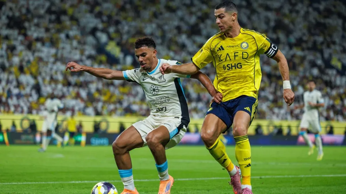 Cristiano Ronaldo do Al-Nassr FC compete pela bola com Ahmed Al-Julaydan do Al-Ittihad FC.