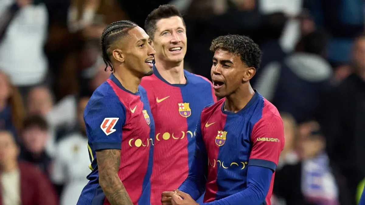 Raphinha do FC Barcelona comemora o quarto gol de seu time com os companheiros Robert Lewandowski e Lamine Yamal durante a partida da LaLiga entre Real Madrid CF e FC Barcelona no Estádio Santiago Bernabeu em 26 de outubro de 2024 em Madrid, Espanha.