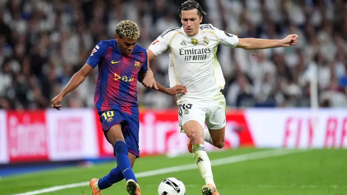 Lamine Yamal, do FC Barcelona, passa a bola sob pressão de Álvaro Carreras, do Real Madrid.