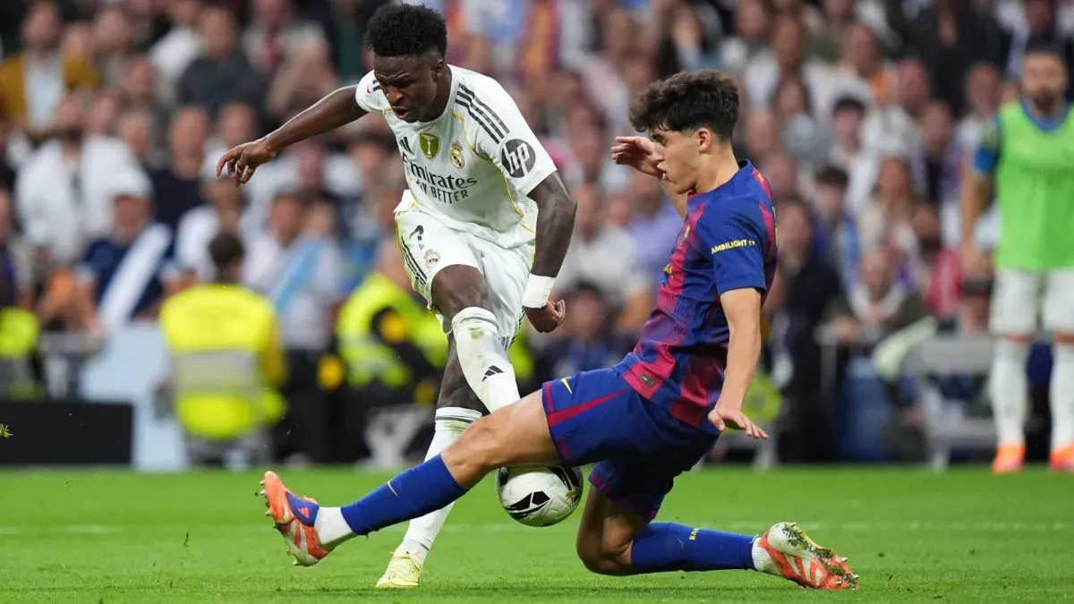 Vinicius Jr, astro do Real Madrid, sendo coberto por Pau Cubarsi do Barcelona