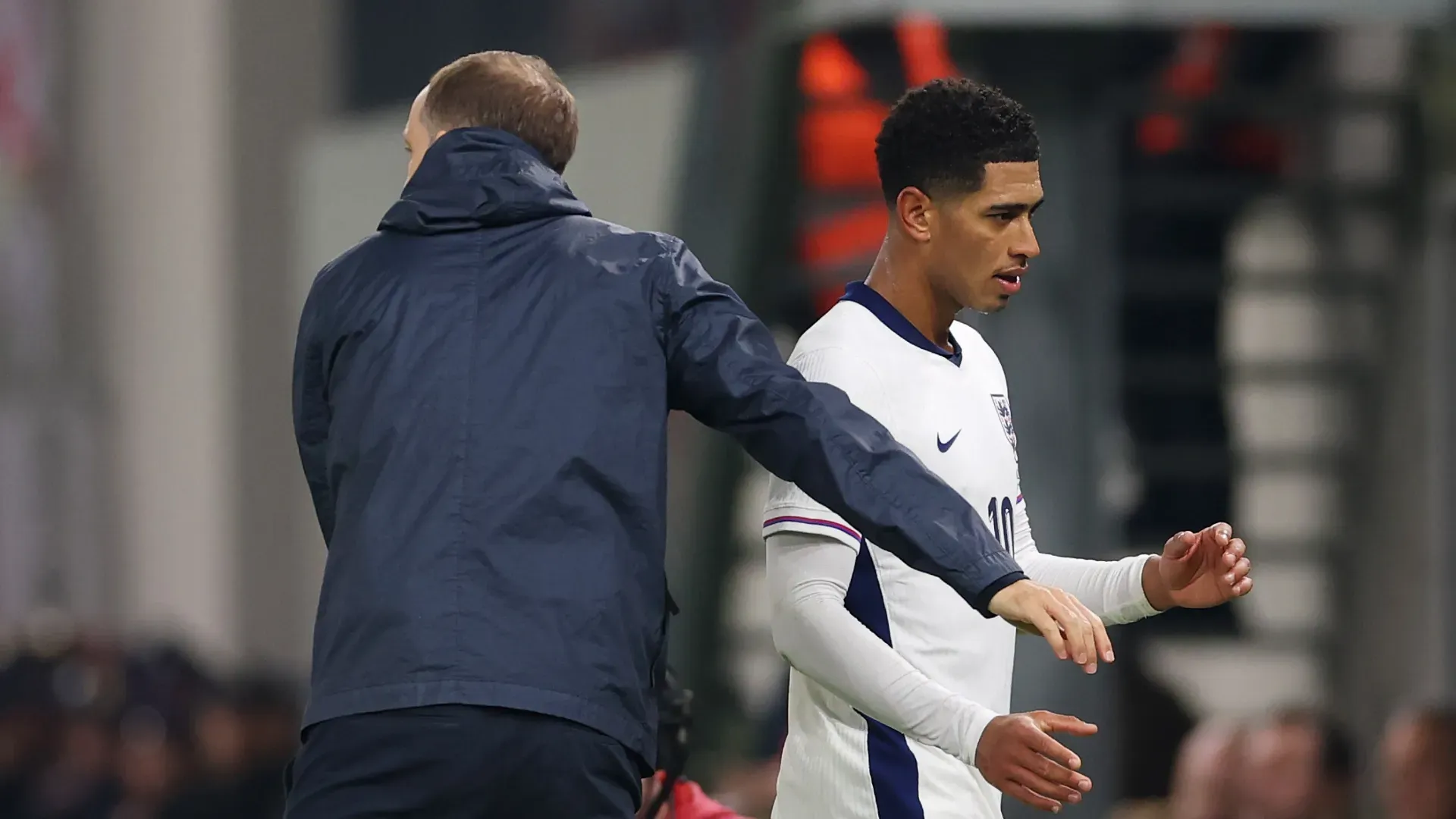 Jude Bellingham, da Inglaterra, ultrapassa Thomas Tuchel, técnico da Inglaterra, após ser substituído.