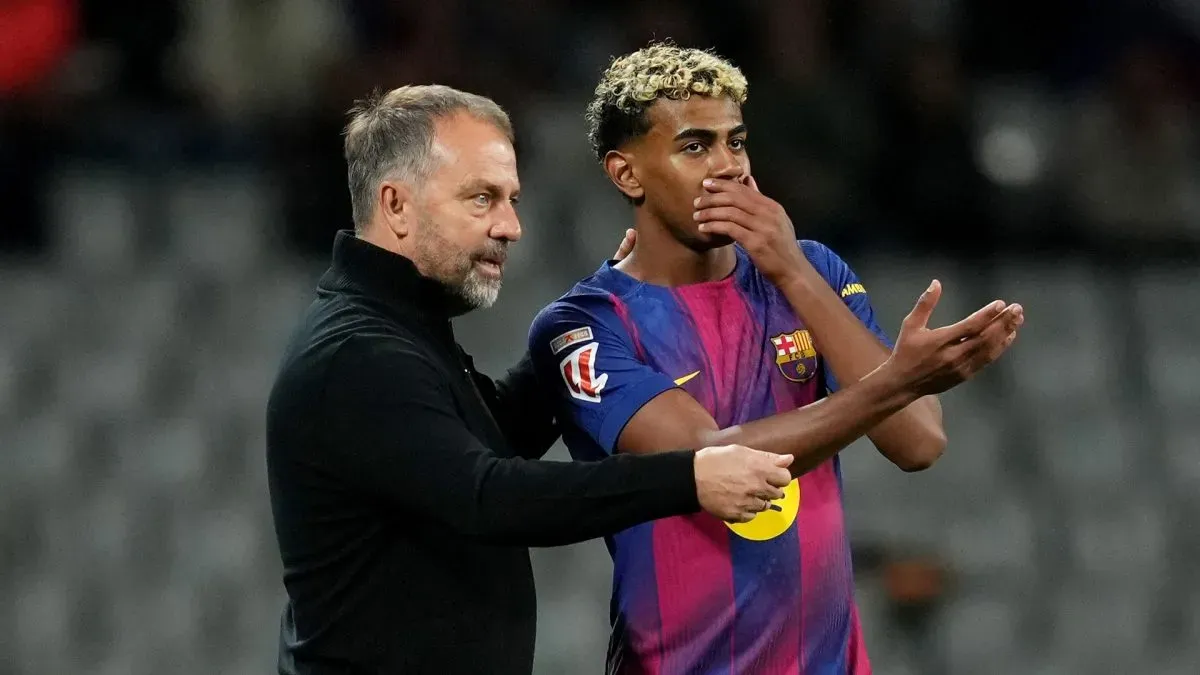 Hansi Flick, treinador principal do FC Barcelona, ​​conversa com Lamine Yamal.