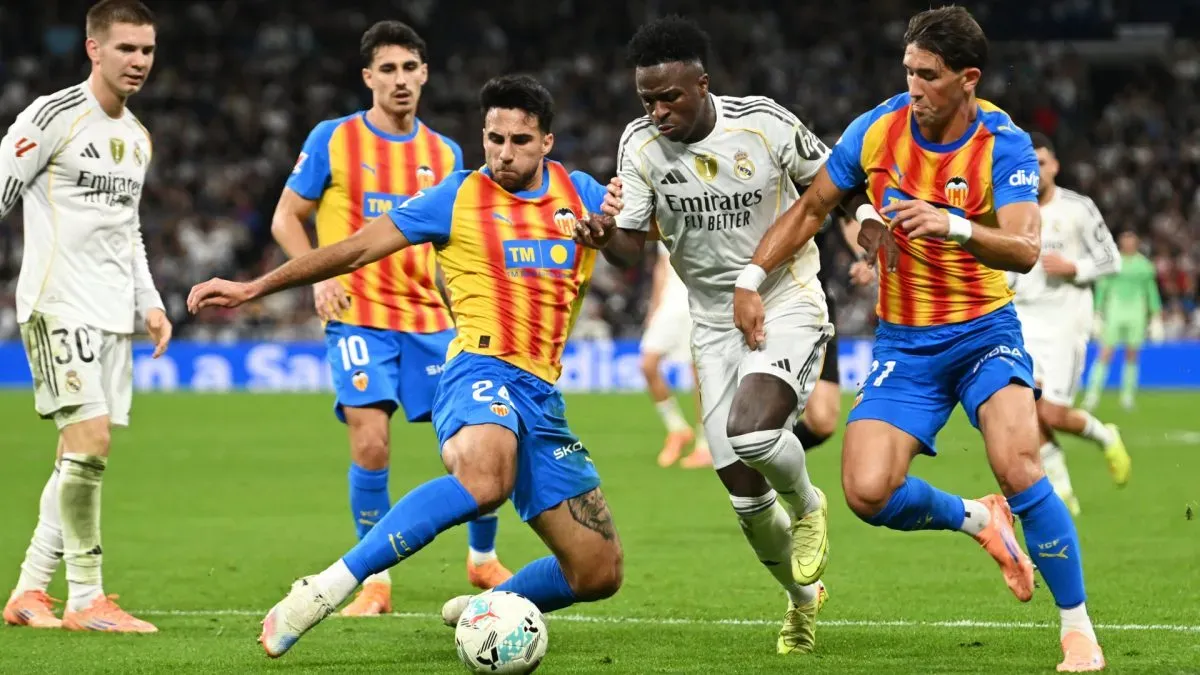 Vinicius Junior brigando pela bola contra os jogadores do Valencia Eray Coemert e Jesus Vazquez