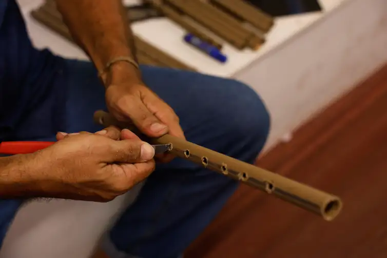 Belém (PA), 18/11/2025 - O músico Renato do Pife constroi pífano para a oficina musical na biblioteca comunitária, galeria e café Gueto Hub, no bairro Jurunas, periferia de Belém. Foto: Tânia Rêgo/Agência Brasil