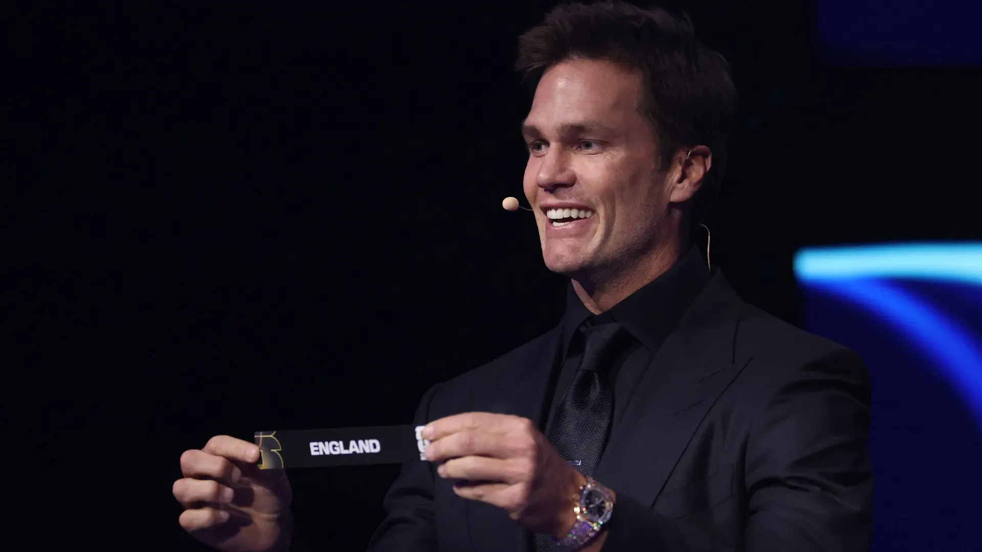 O assistente de sorteio Tom Brady tira o cartão da Inglaterra durante o sorteio oficial da Copa do Mundo FIFA 2026.