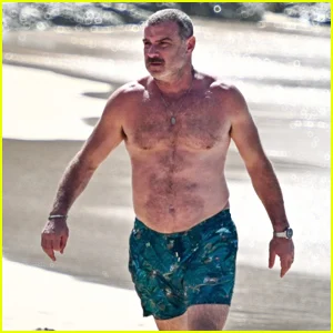 Liev Schreiber fica sem camisa ao chegar à praia em Barbados