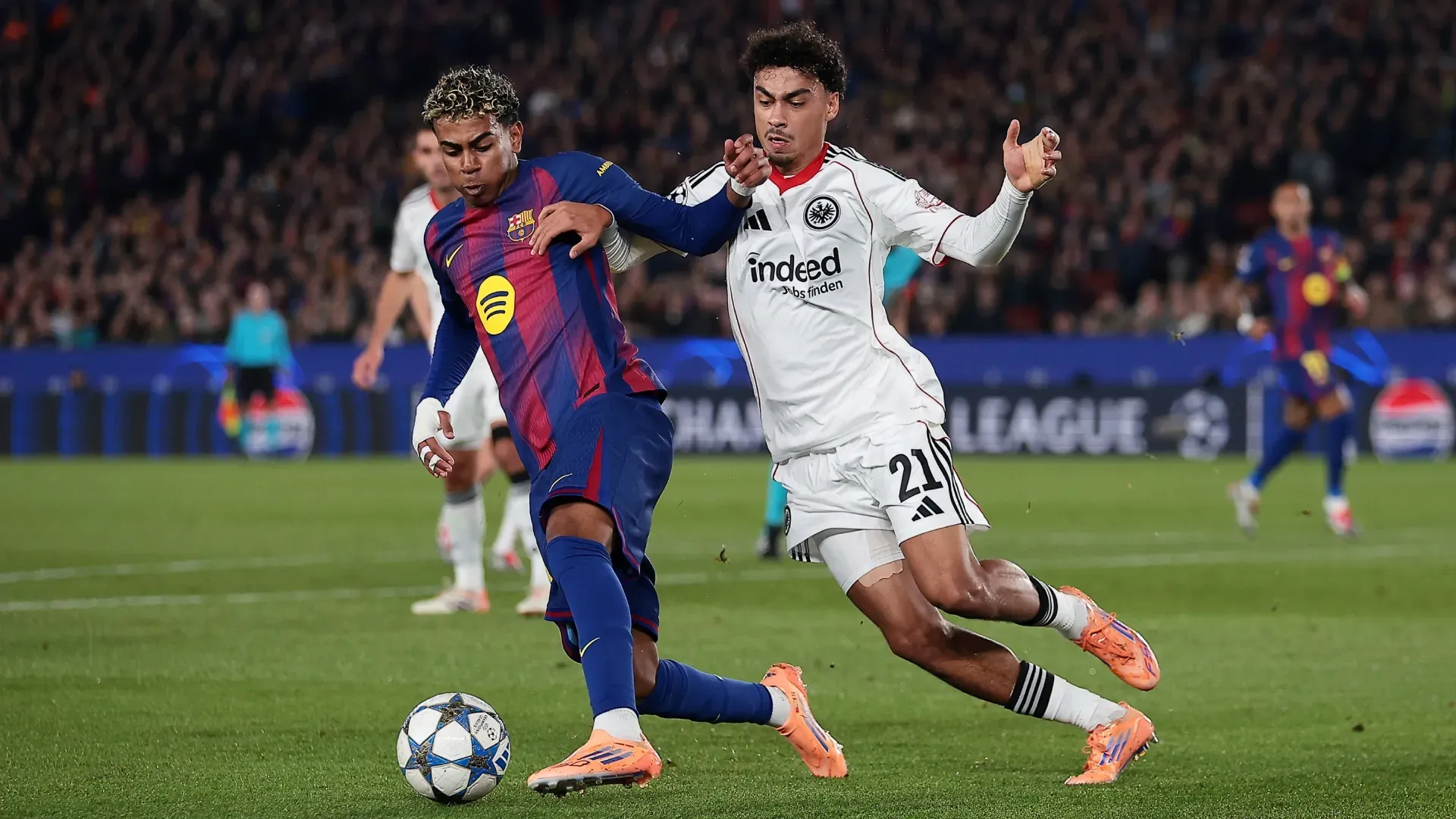 Lamine Yamal do FC Barcelona é desafiado por Nathaniel Brown do Eintracht Frankfurt.