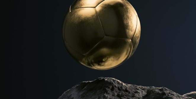 a golden soccer ball sitting on top of a rock