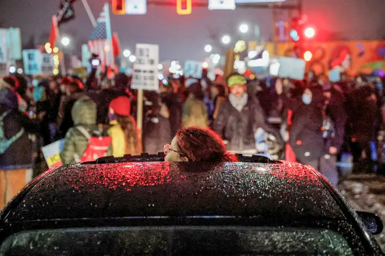 A person looks through a vehicle’s sunroof as people protest against increased immigration enforcement, a day after a U.S. Immigration and Customs Enforcement (ICE) agent fatally shot Renee Nicole Good, in Minneapolis, Minnesota, U.S., January 8, 2026. REUTERS/Brian Snyder     TPX IMAGES OF THE DAY