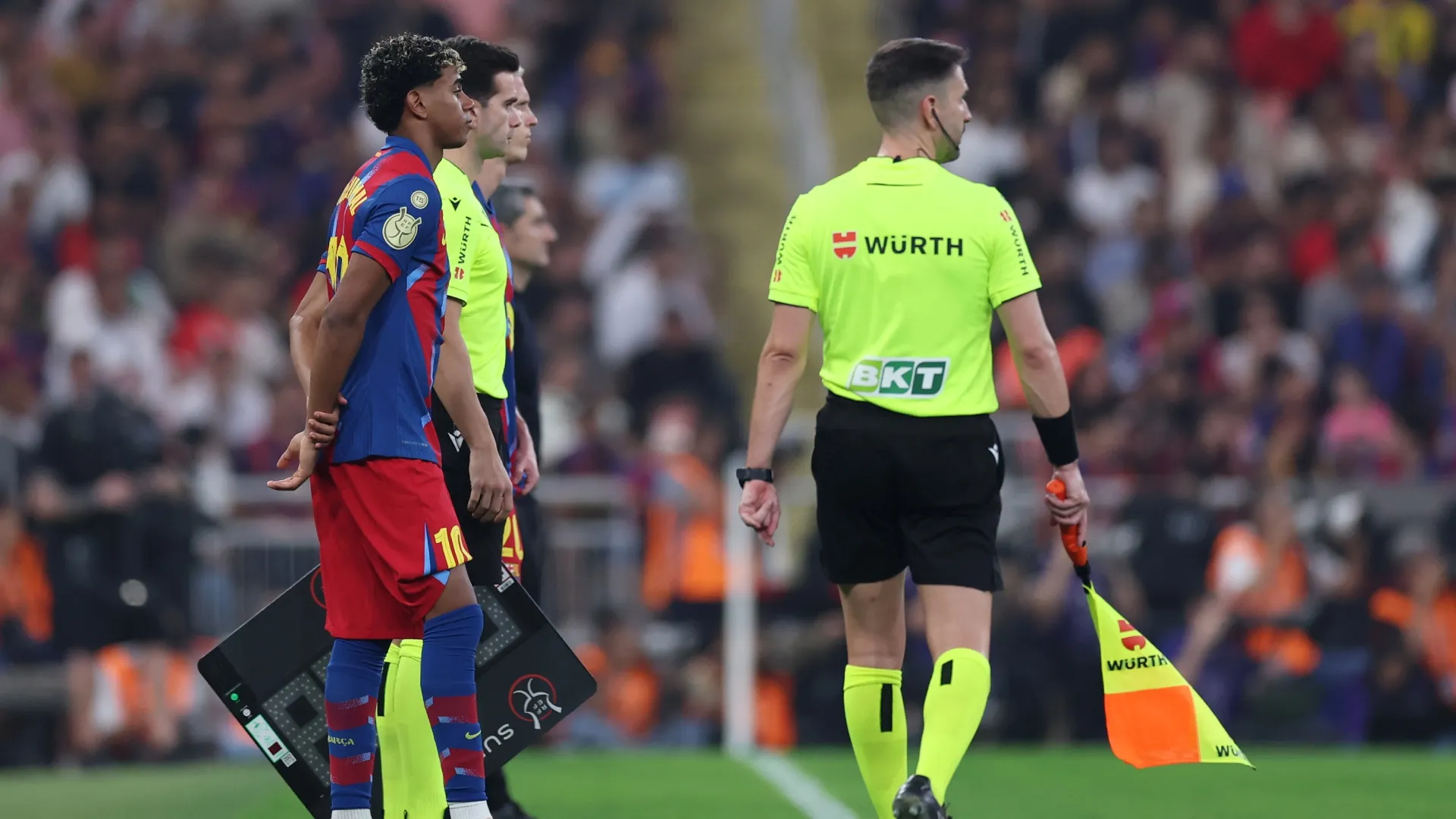 Lamine Yamal, do FC Barcelona, ​​observa na linha lateral enquanto se prepara para ser substituído.