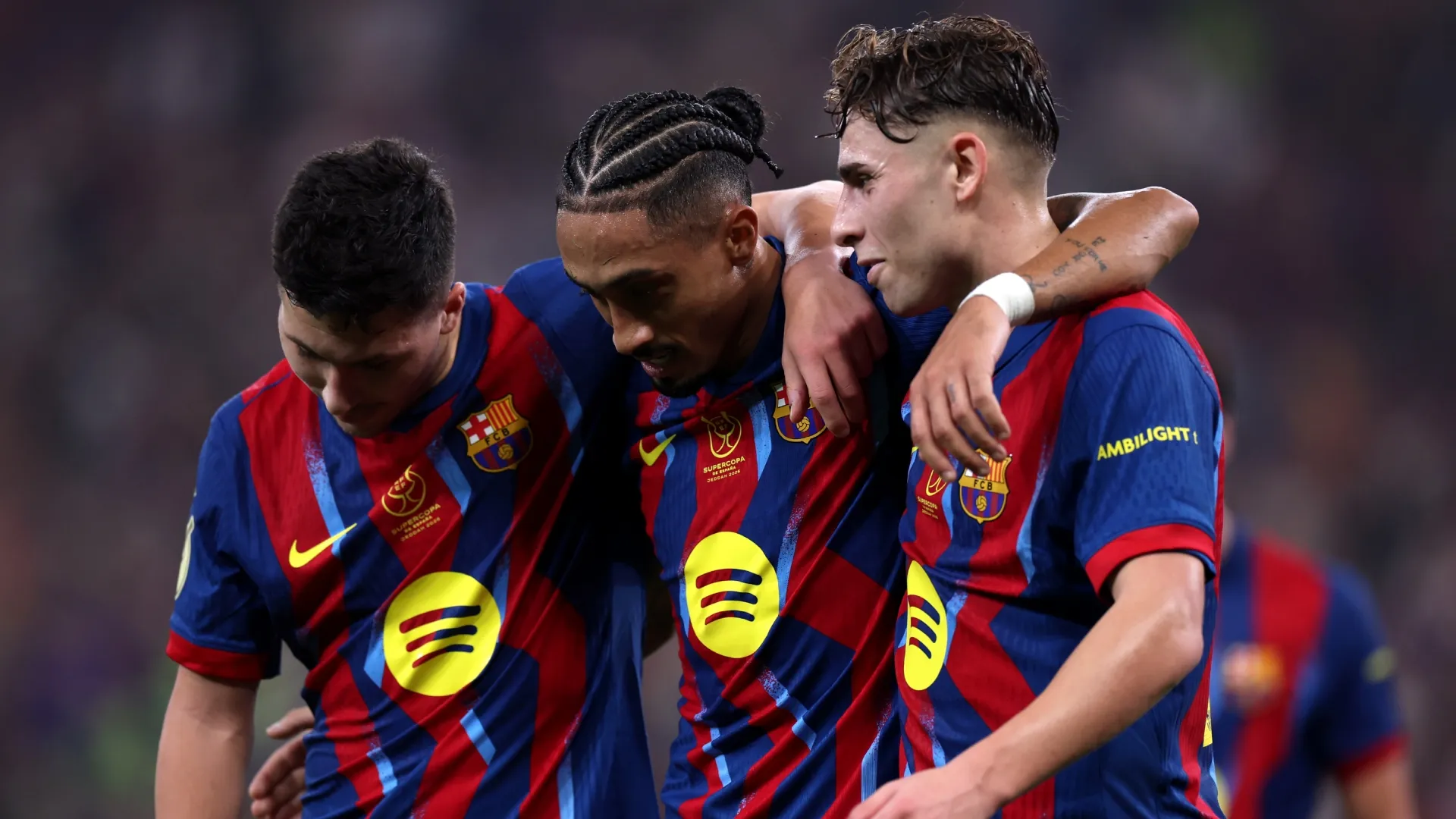 Raphinha do FC Barcelona comemorando com Fermin Lopez e Roony Bardghji.