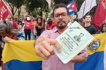 Rio de Janeiro (RJ), 05/01/2026 - Ali Alvarez, de 31 anos - Manifestante mostra constituição da Venezuela durante ato na Cinelândia contra a invasão dos Estados Unidos na Venezuela. Foto: Gilberto Costa/Agência Brasil