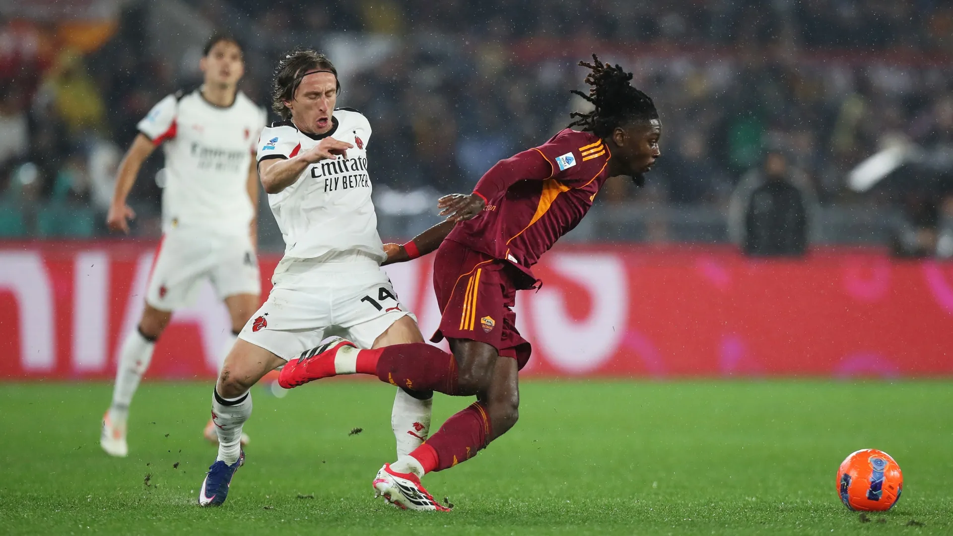 Manu Kone, da AS Roma, é desafiado por Luka Modric, do AC Milan.