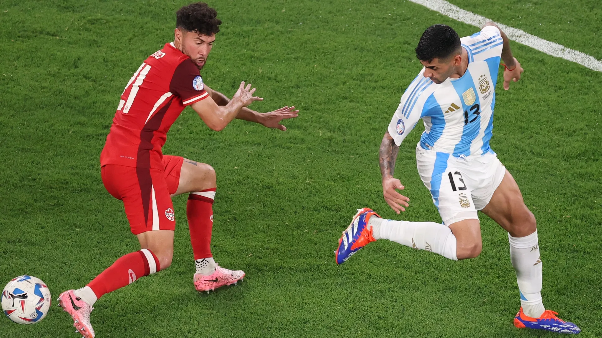 Cristian Romero, da Argentina, luta pela bola com Jonathan Osorio, do Canadá.