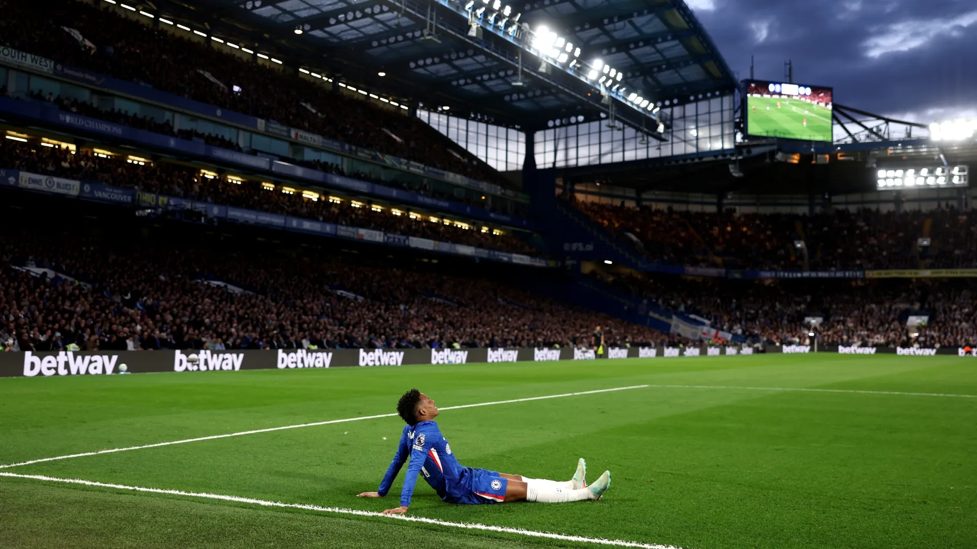Estevão, do Chelsea, reage com lesão durante o jogo contra o Manchester United.