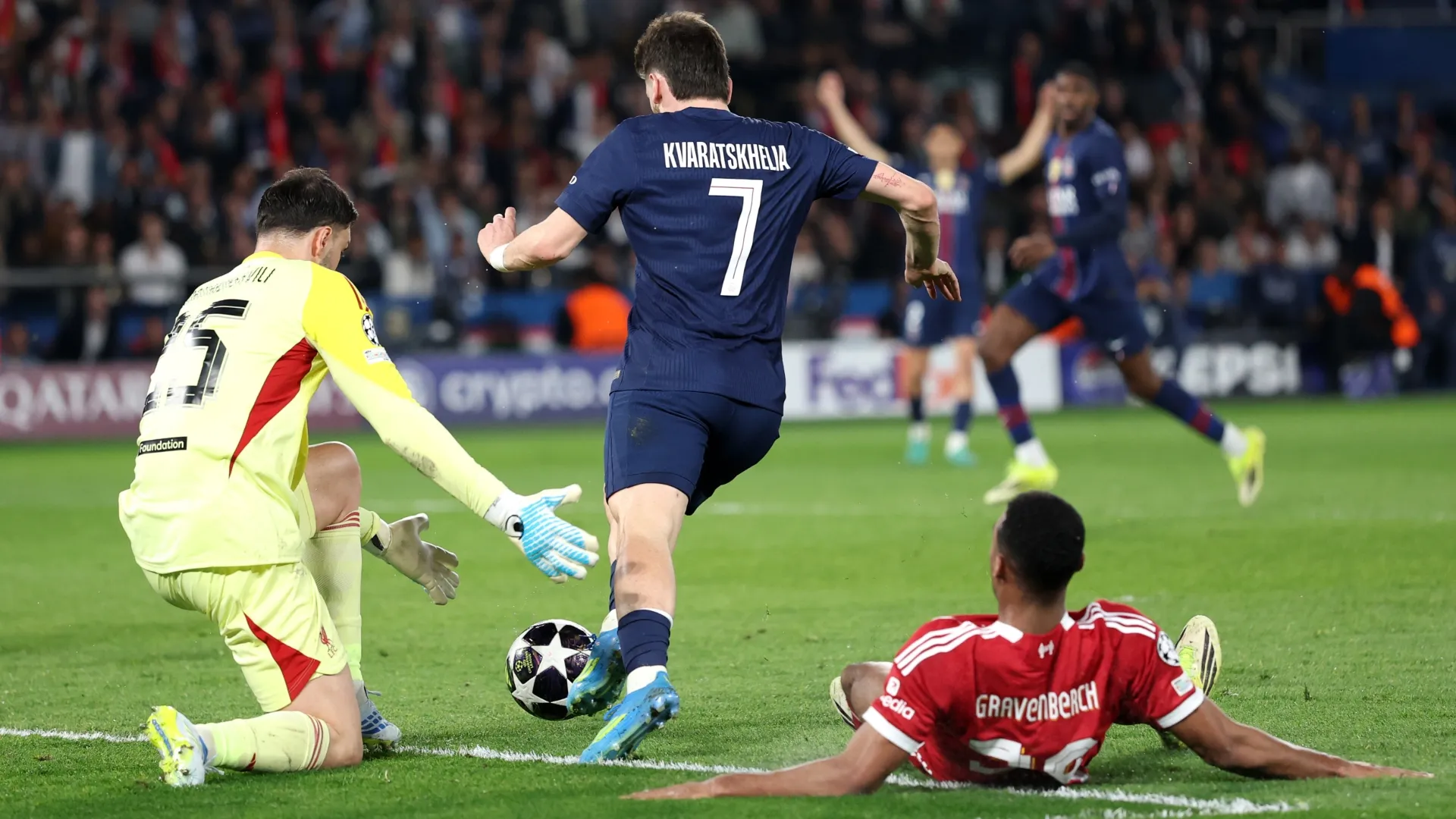 Khvicha Kvaratskhelia, do Paris Saint-Germain, contorna Giorgi Mamardashvili, do Liverpool, para marcar um gol.