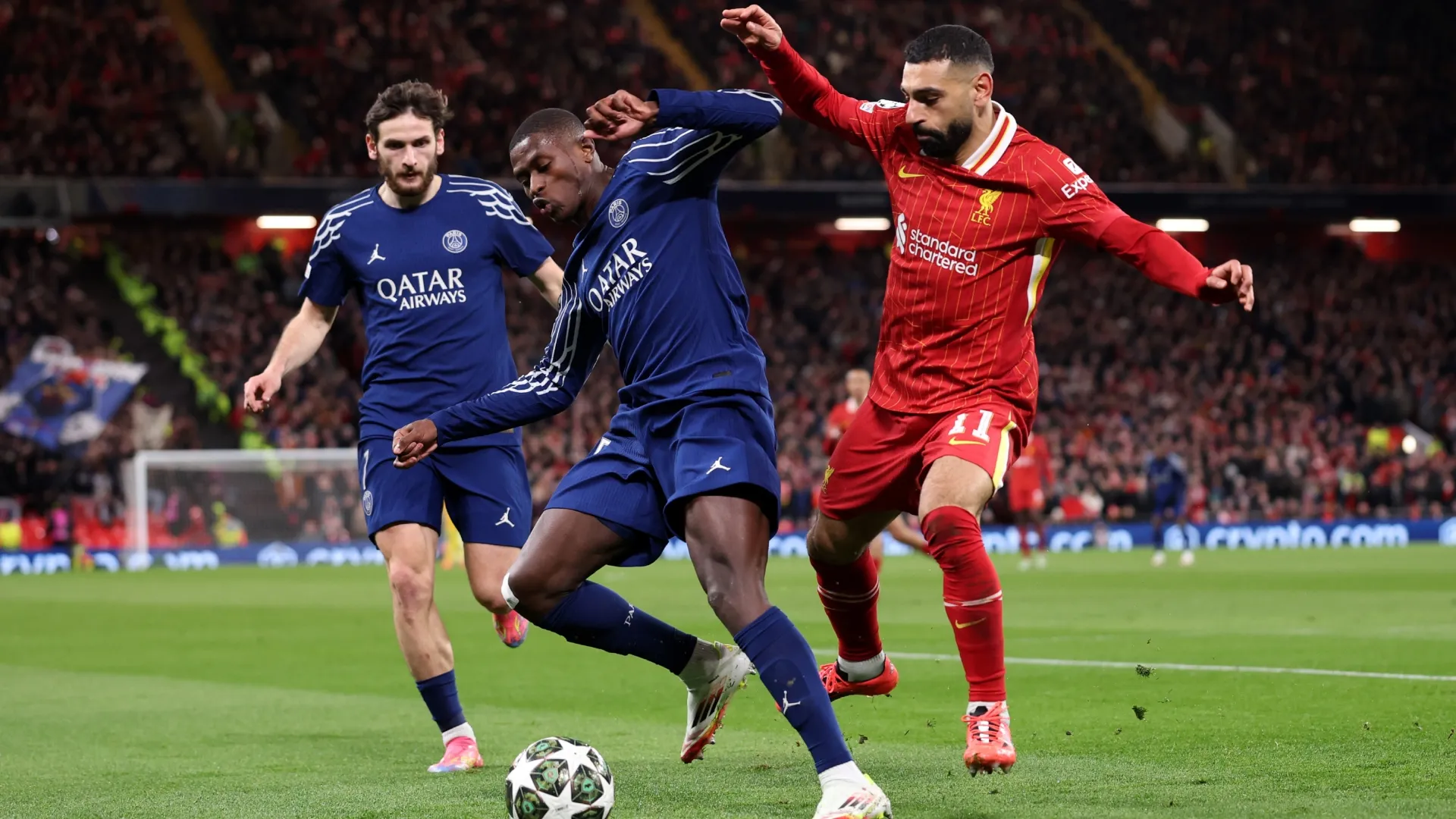 A estrela do PSG, Nuno Mendes, controla a bola sob pressão da estrela do Liverpool, Mohamed Salah