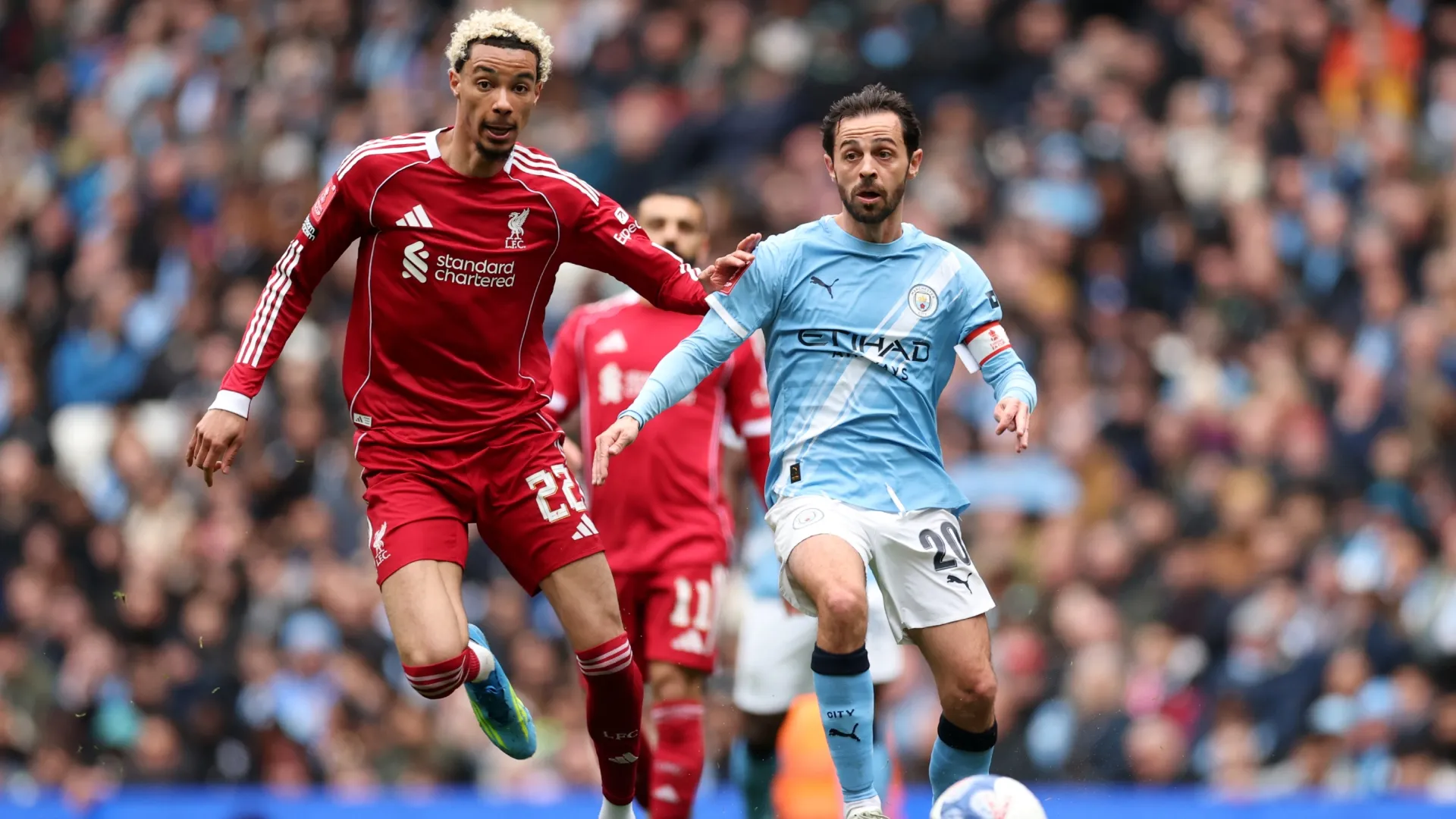 Hugo Ekitike do Liverpool desafia Bernardo Silva do Manchester City.