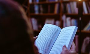 person reading book in library