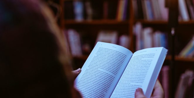 person reading book in library