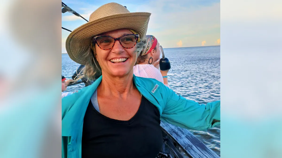 Lynette Hooker standing outdoors wearing a hat and sunglasses