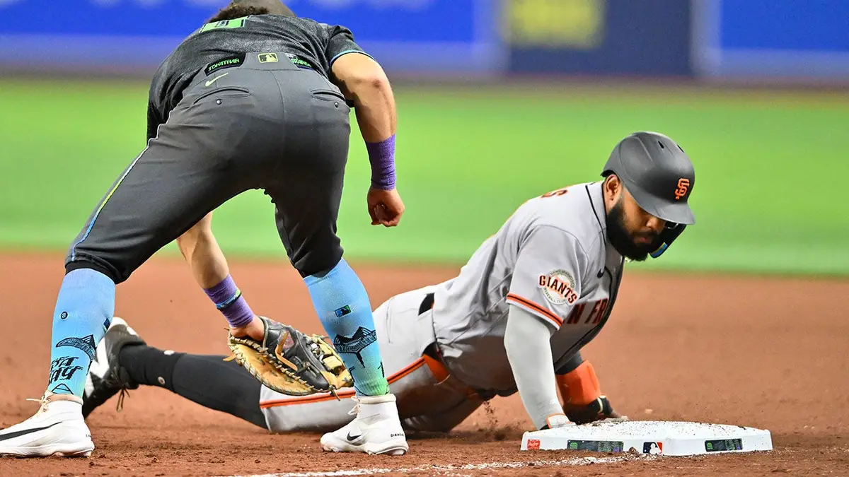 San Francisco Giants Heliot Ramos sliding to first base as Tampa Bay Rays first baseman Jonathan Aranda tags him at Tropicana Field
