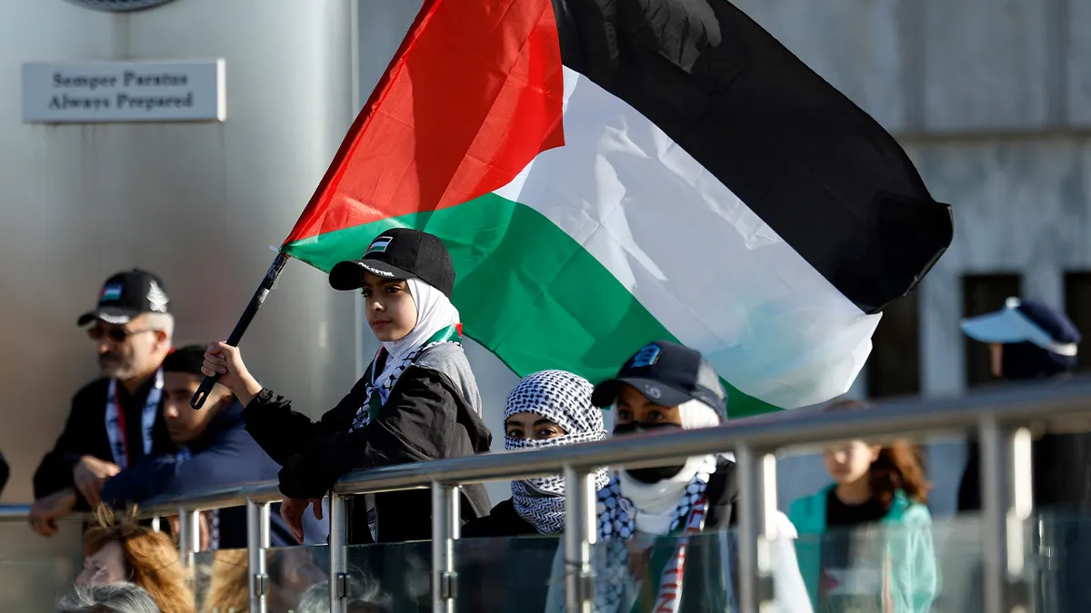 A young girl holding a Palestinian flag during a prayer vigil outside Henry Ford Centennial Library in Dearborn