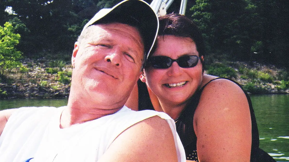 Jeff Walton wearing a white tank top leaning against a smiling Deb Proctor in a black tank top.