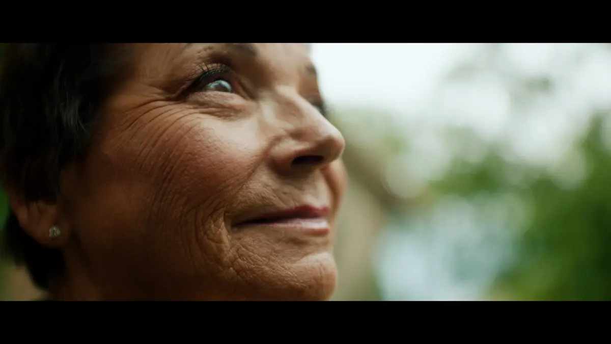 A close-up screenshot of Deb Proctor smiling away from the camera.