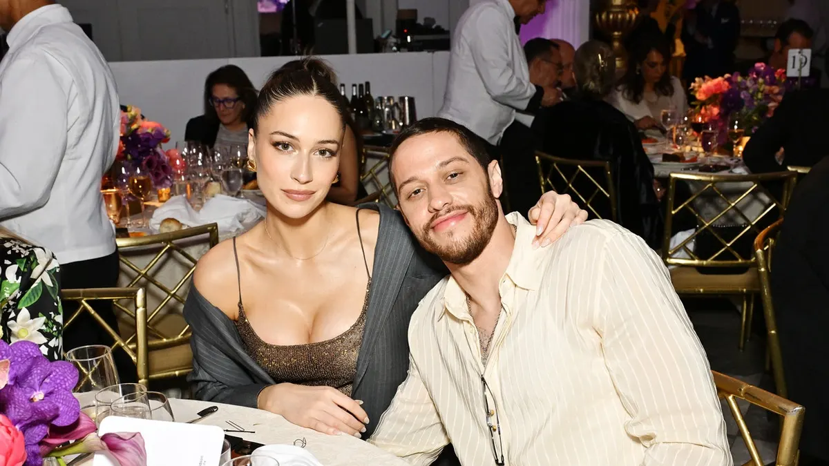 Elsie Hewitt and Pete Davidson sit at a table at a gala