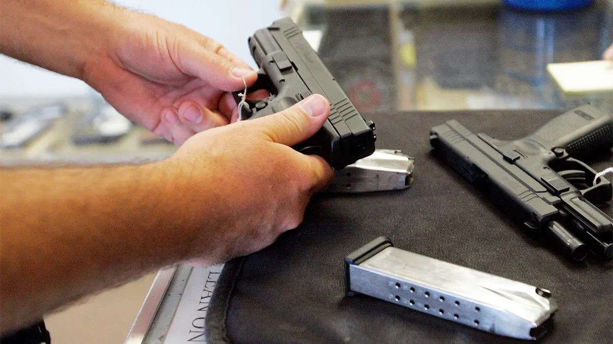 A customer inspects a 9mm handgun