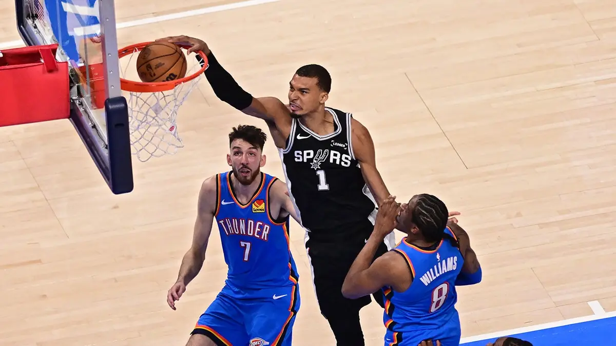 Victor Wembanyama dunks the ball against Chet Holmgren and Jalen Williams during NBA game