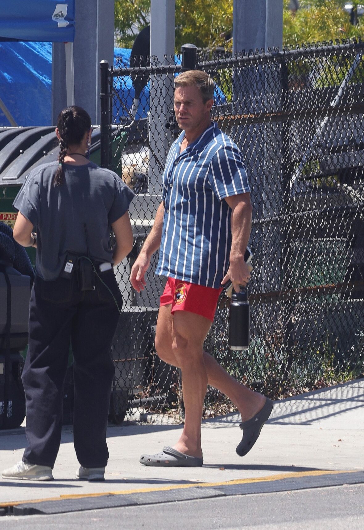Stephen Amell chega ao set de BAYWATCH com o icônico calção de banho vermelho e camisa listrada