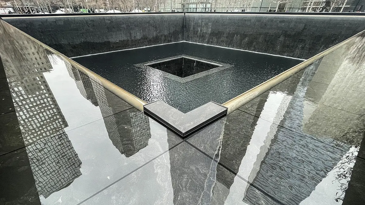 Freedom Tower reflected in the Reflecting Pool at the 9/11 Memorial in New York City.