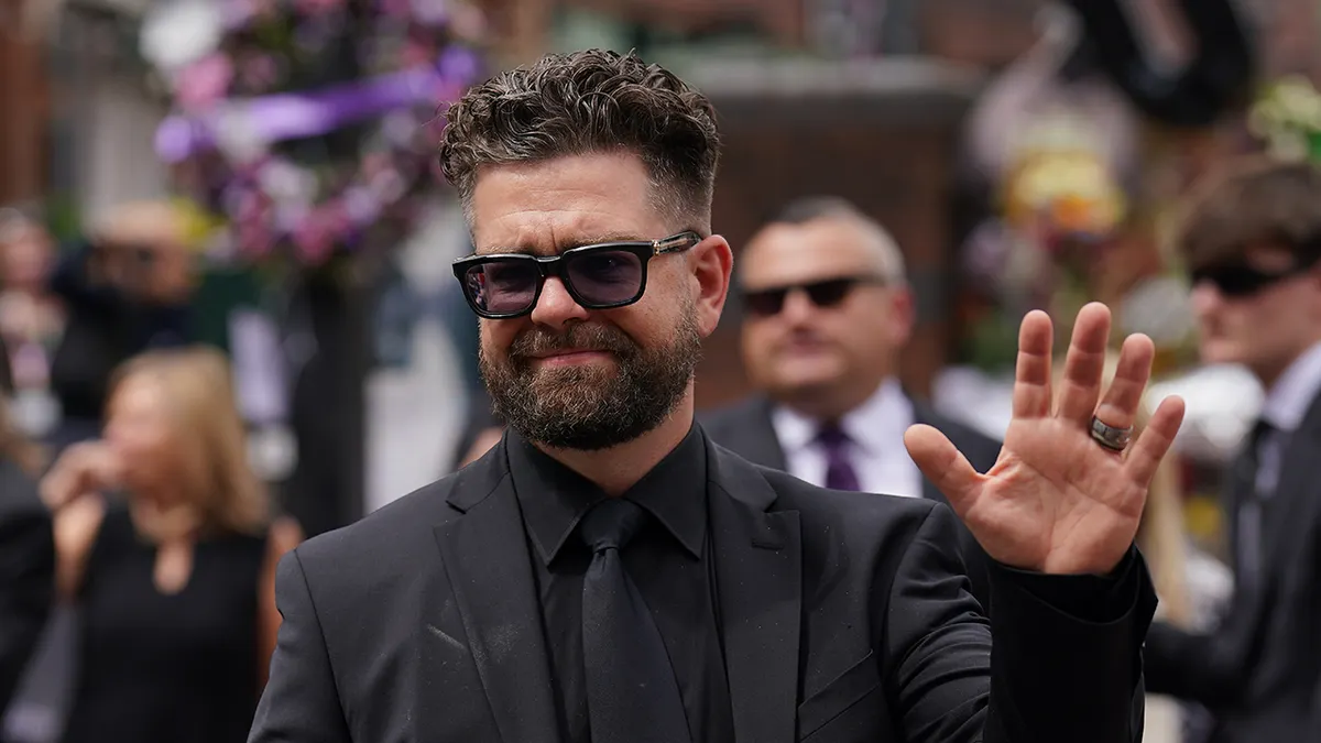 Jack Osbourne waving to crowd at Black Sabbath Bridge bench in Birmingham