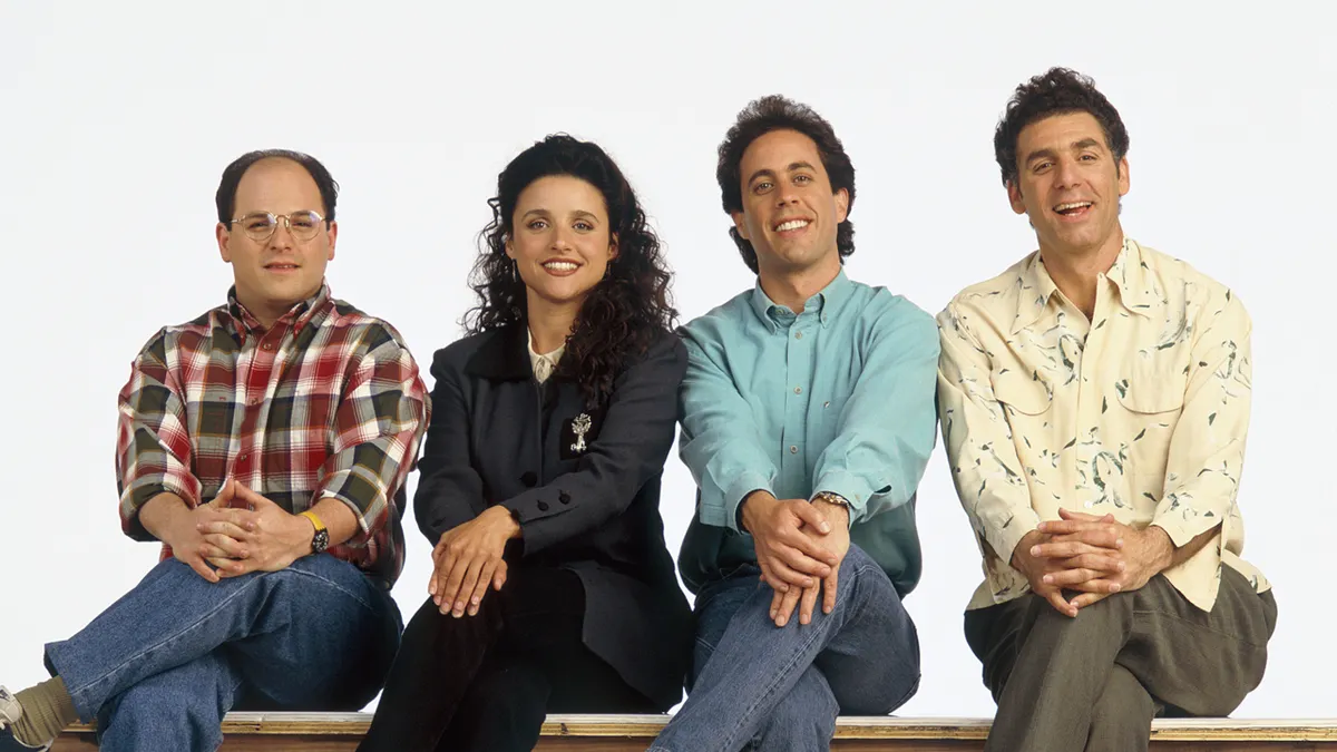 Jason Alexander as George Costanza, Julia Louis-Dreyfus as Elaine Benes, Jerry Seinfeld as Jerry Seinfeld, Michael Richards as Cosmo Kramer posing for a promotional photo.