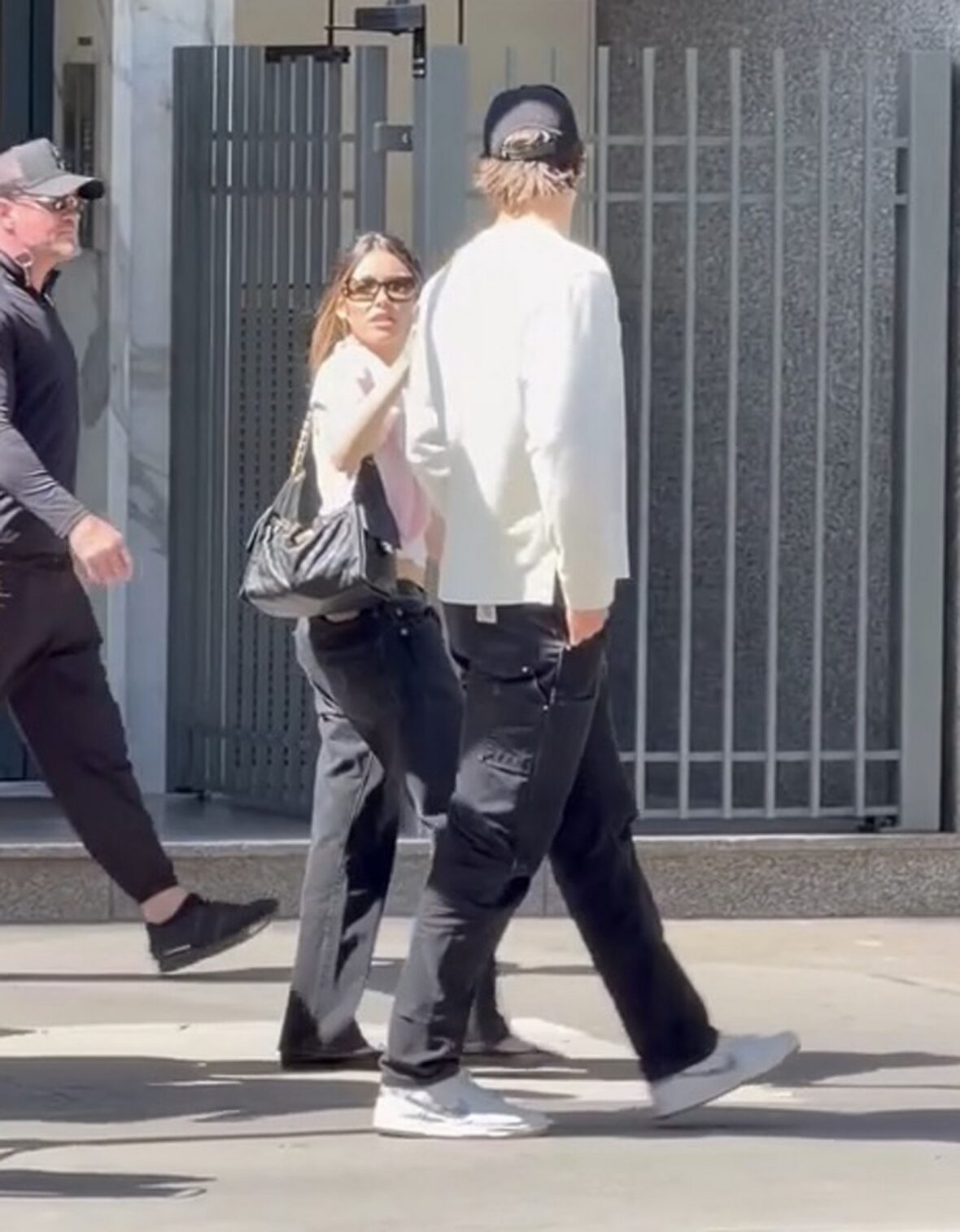Justin Herbert e Madison Beer caminham lado a lado ao ar livre