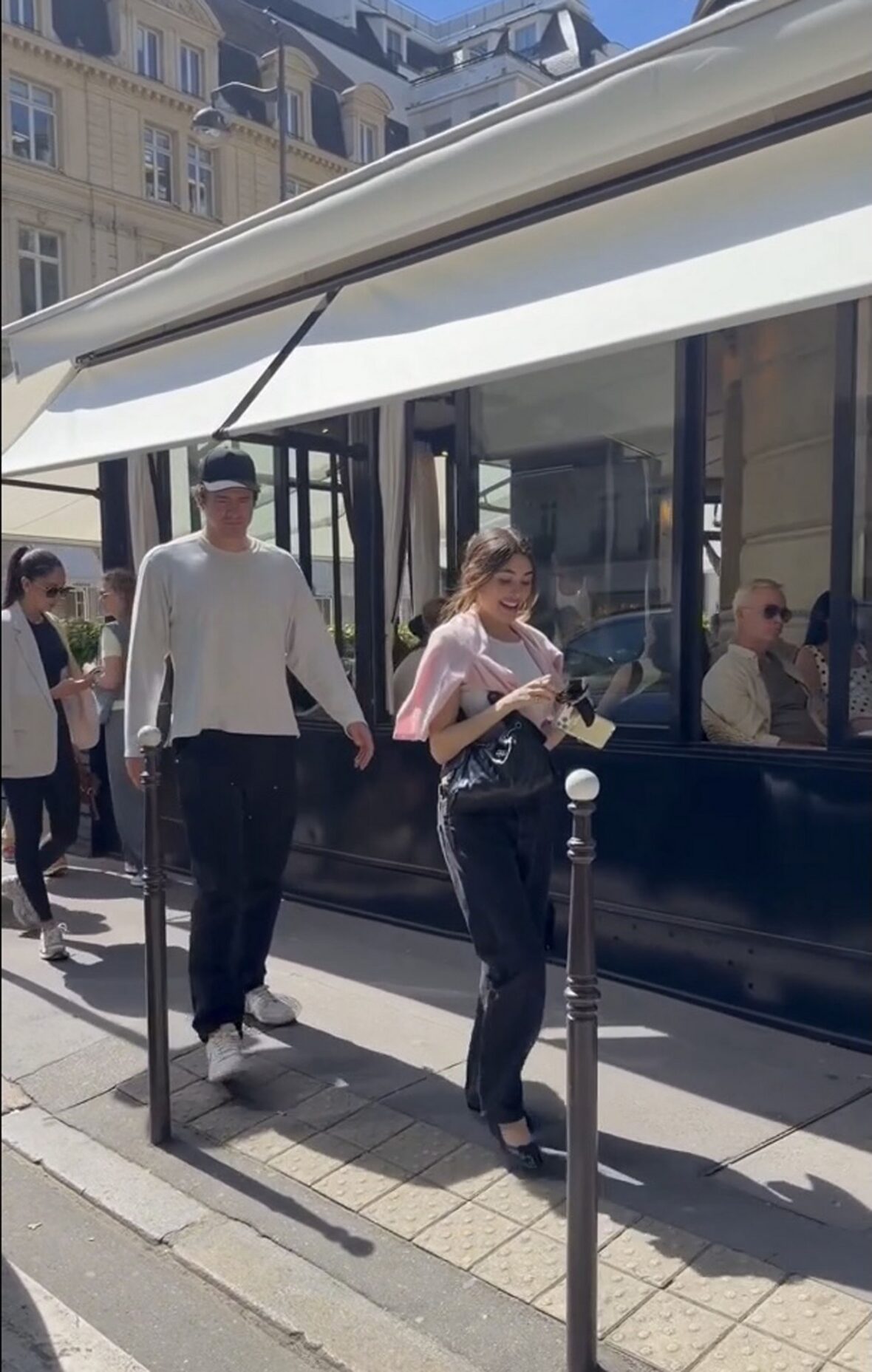 Justin Herbert e Madison Beer caminham lado a lado ao ar livre