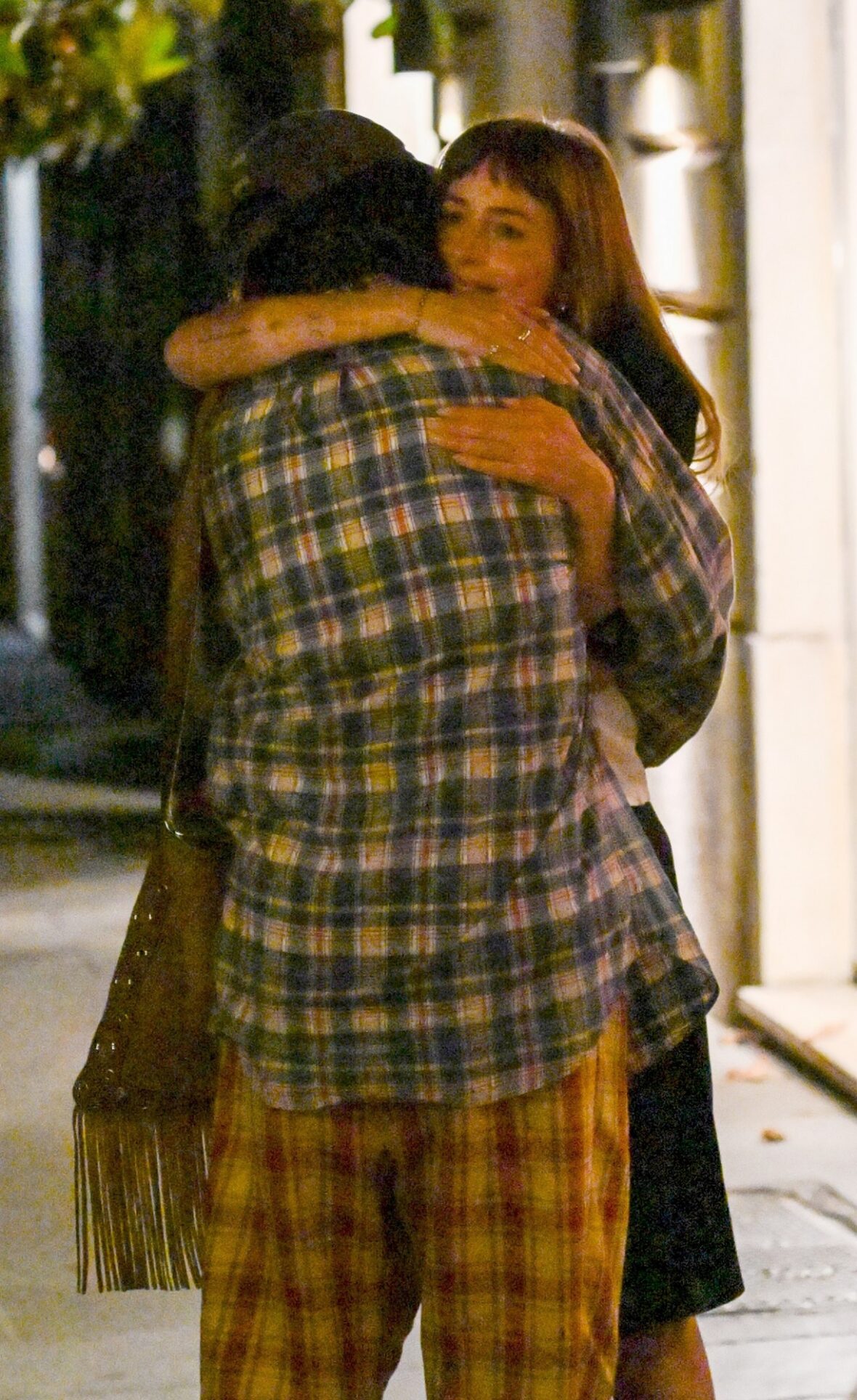 Dakota Johnson e Alessandro Michele se abraçando