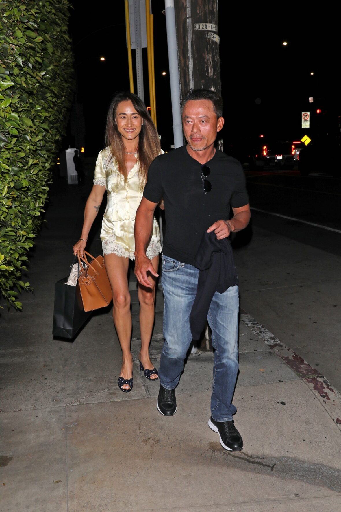 Maggie Q e Curtis Macnguyen de mãos dadas 