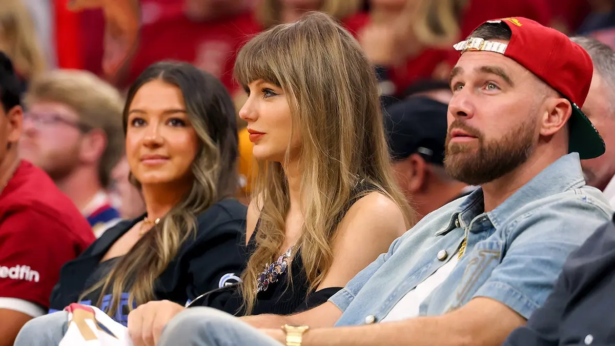 Singer Taylor Swift and Travis Kelce seated at Rocket Arena during NBA Eastern Conference Finals game.