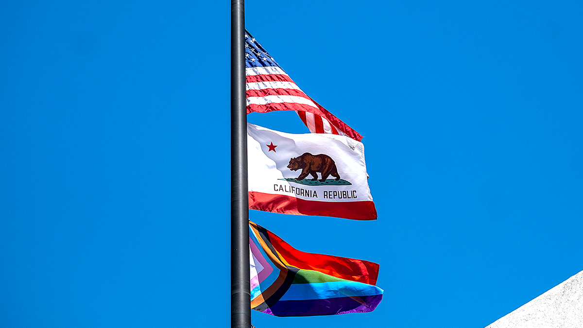California, US and Progress Pride flags shown raised on flagpole
