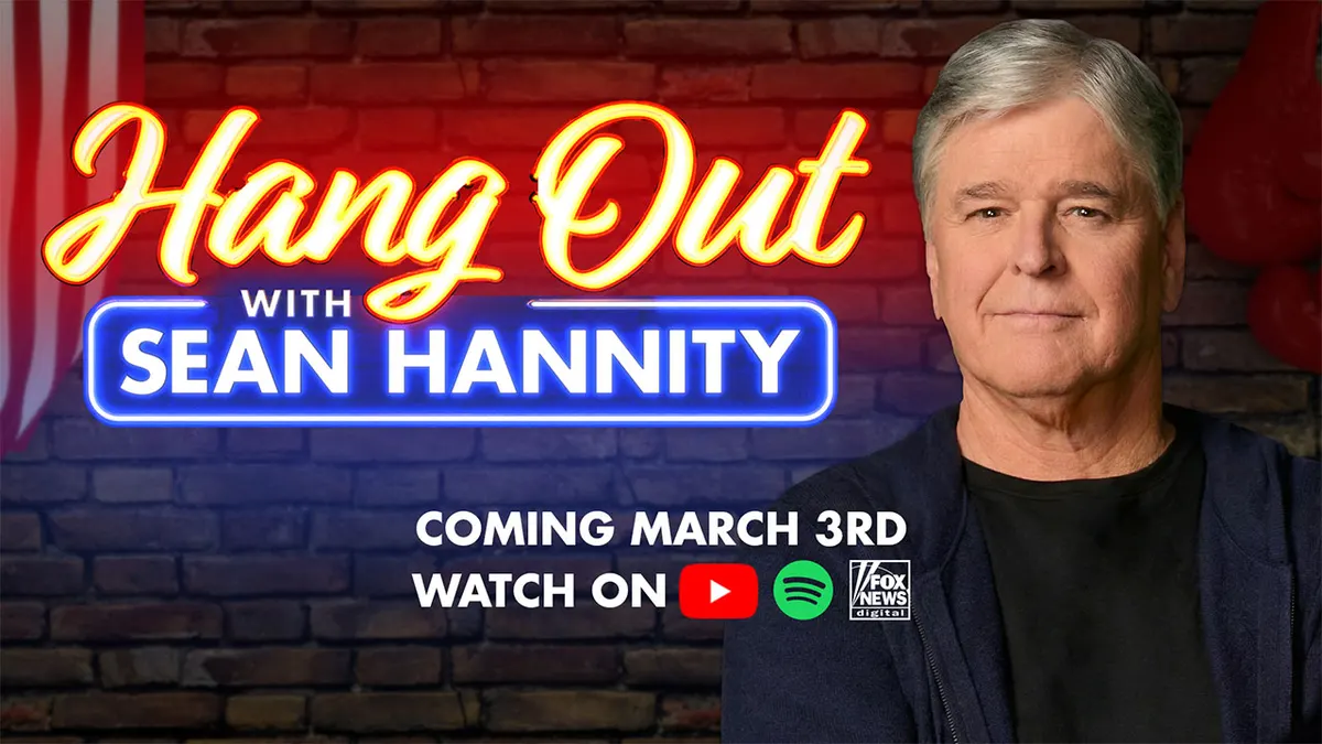 Sean Hannity smiling and seated in a studio