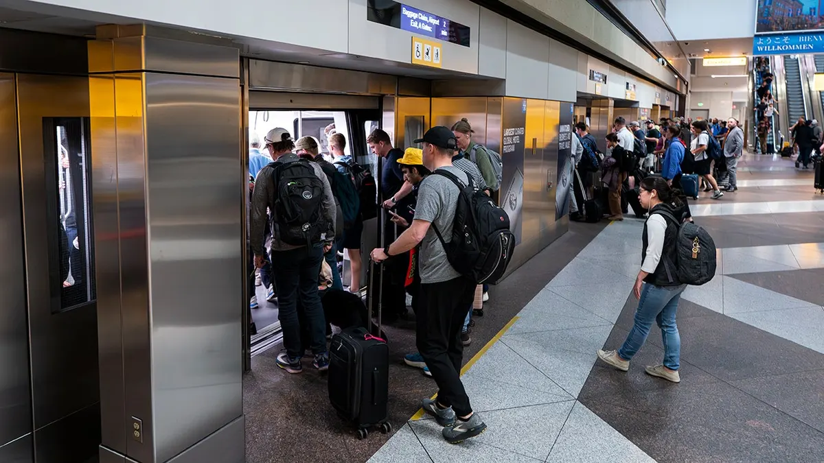 Travelers boarding the Automated Guideway Transit System people mover at Denver International Airport.