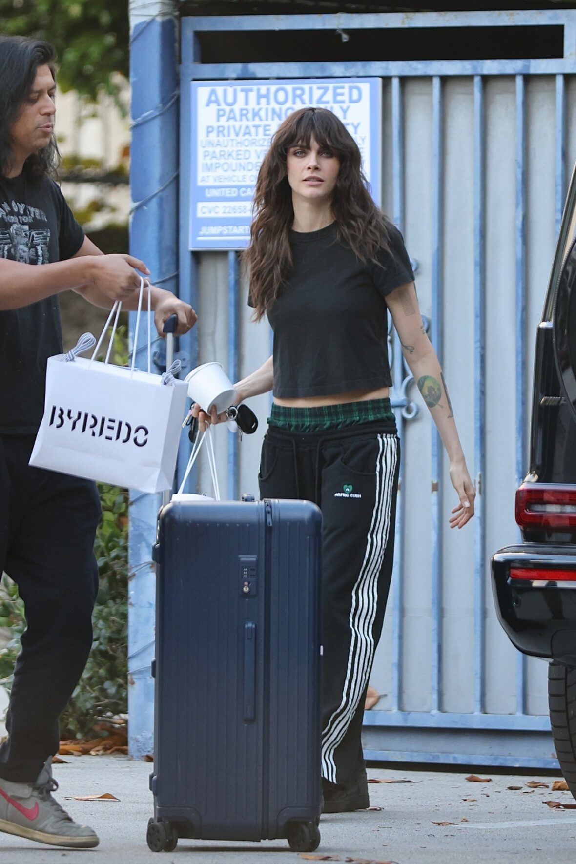 Cara Delevingne chega ao show com camiseta preta