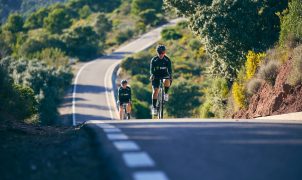 a couple of people riding bikes down a road